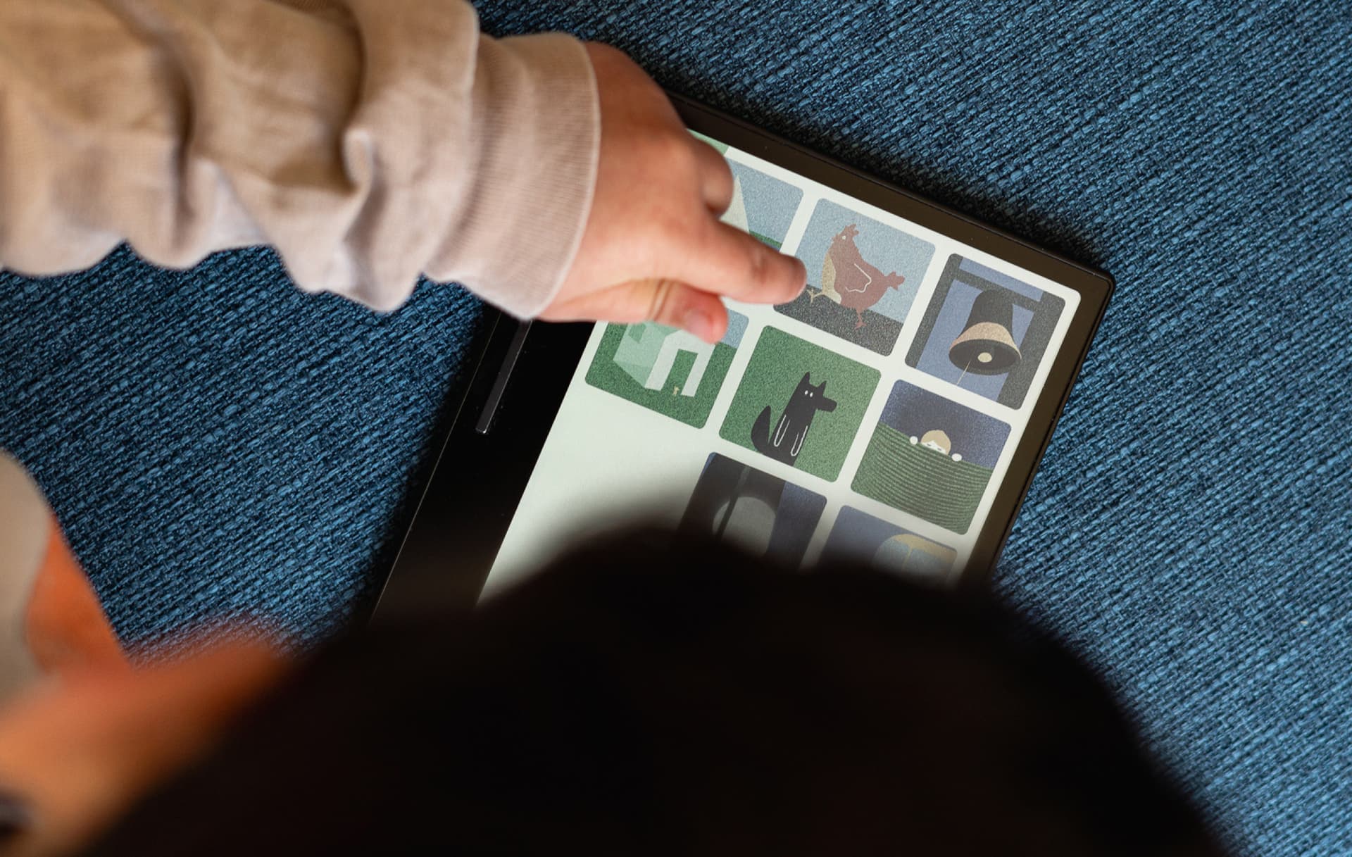 Child holding Miniberry cards on tablet
