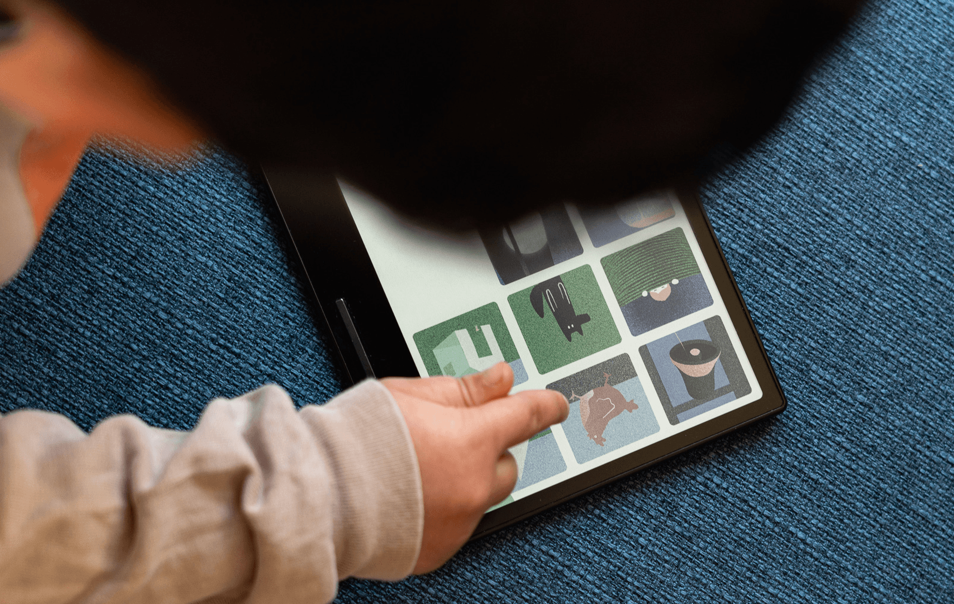 Child holding Miniberry cards on tablet
